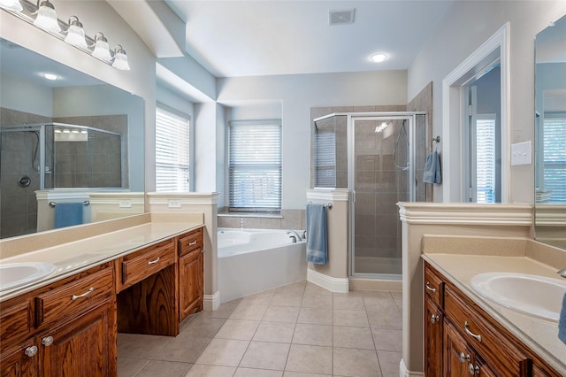 bathroom featuring visible vents, two vanities, a stall shower, a sink, and tile patterned flooring