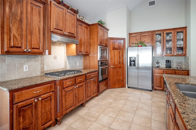 kitchen with brown cabinetry, visible vents, under cabinet range hood, and stainless steel appliances