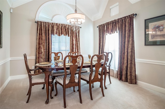 dining space featuring light carpet, a notable chandelier, lofted ceiling, ornamental molding, and baseboards