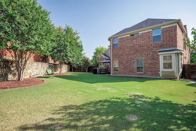 exterior space with central AC and a fenced backyard