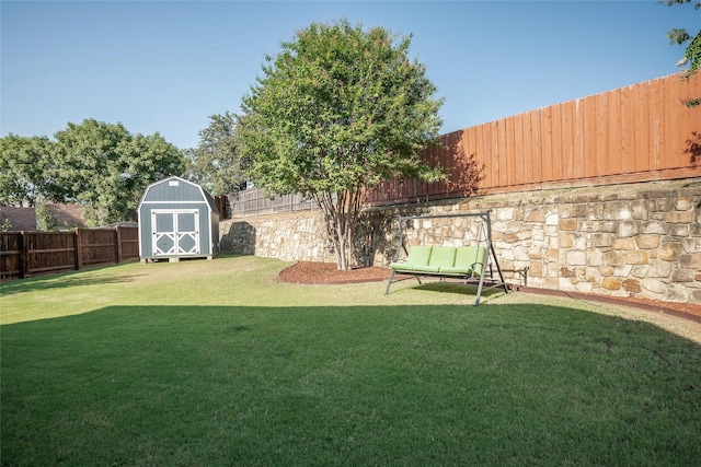 view of yard featuring a storage unit, a fenced backyard, and an outdoor structure