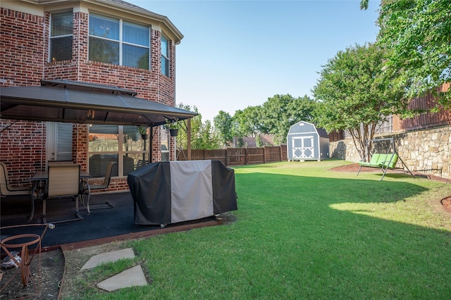 view of yard with a gazebo, a storage shed, a fenced backyard, an outdoor structure, and a patio