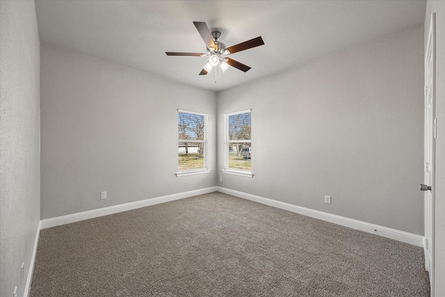 carpeted spare room featuring ceiling fan and baseboards