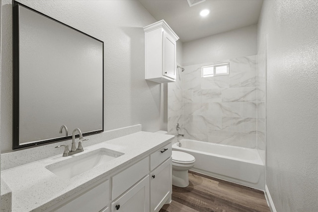 bathroom with visible vents, toilet, shower / bathing tub combination, wood finished floors, and vanity