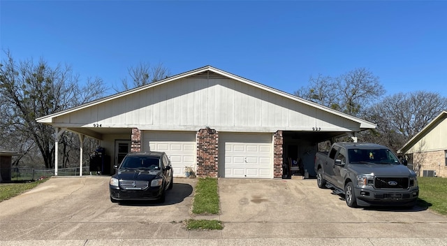 view of side of home with concrete driveway, brick siding, a garage, and central AC