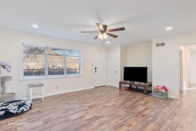 sitting room with visible vents, wood finished floors, and ornamental molding