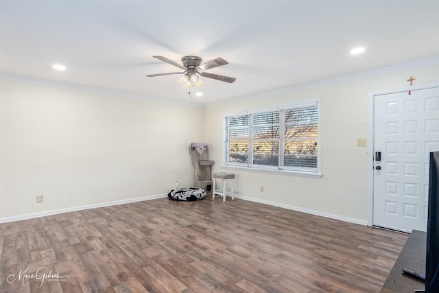 empty room with ceiling fan, wood finished floors, baseboards, and ornamental molding