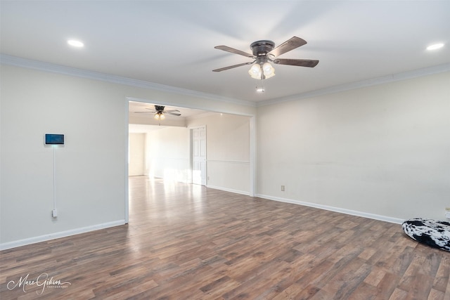 unfurnished room featuring baseboards, wood finished floors, and crown molding