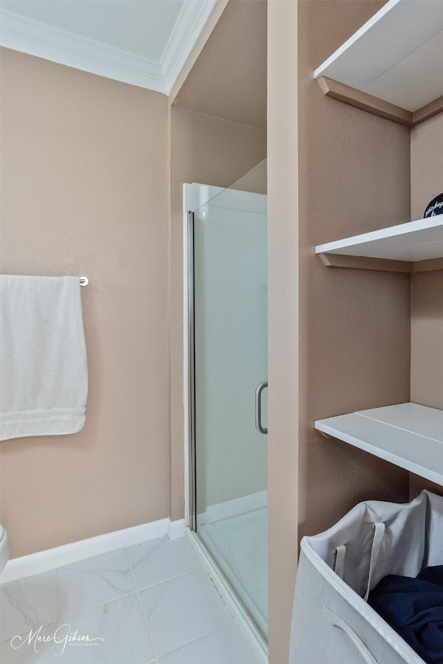 full bath with marble finish floor, a stall shower, baseboards, and ornamental molding