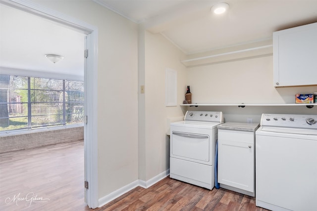 washroom with wood finished floors, cabinet space, baseboards, and washer and clothes dryer