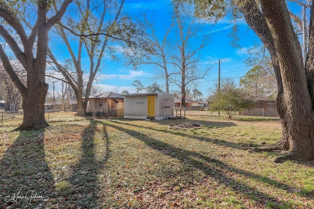 view of yard with fence, an outbuilding, and a shed