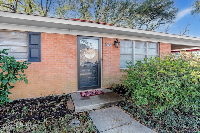 doorway to property with brick siding