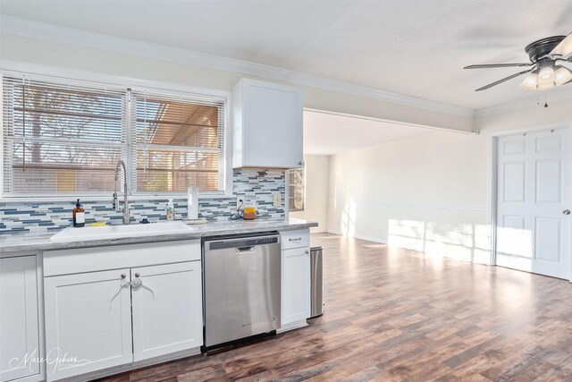 kitchen featuring tasteful backsplash, ornamental molding, stainless steel dishwasher, wood finished floors, and a sink