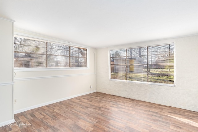 empty room featuring baseboards and wood finished floors