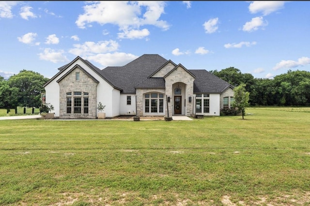 french provincial home featuring a front lawn, stone siding, and a shingled roof