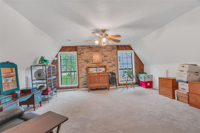 interior space with vaulted ceiling, carpet flooring, and ceiling fan