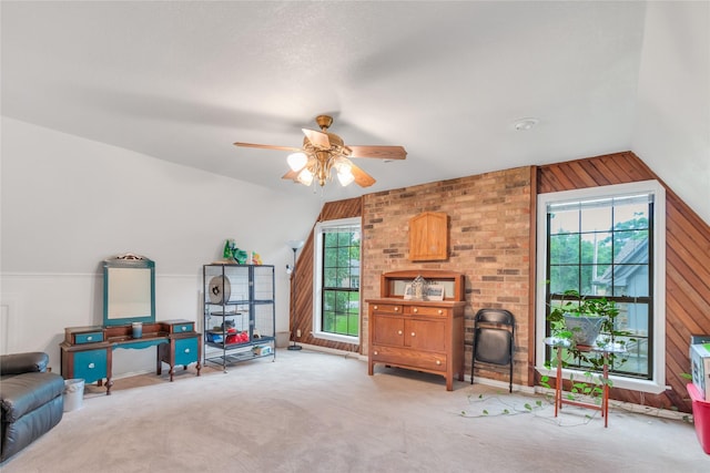 rec room featuring lofted ceiling, carpet floors, wood walls, and a ceiling fan