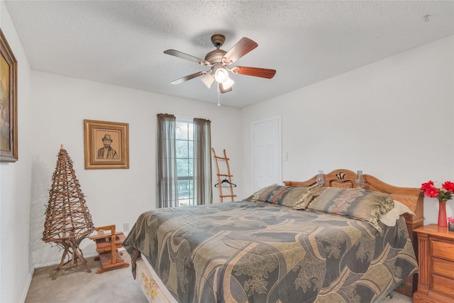 bedroom featuring light carpet, baseboards, a textured ceiling, and a ceiling fan