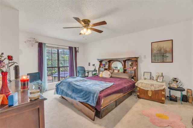 carpeted bedroom featuring a textured ceiling and ceiling fan