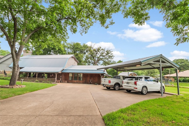 view of front of house featuring metal roof, driveway, a carport, and a front yard