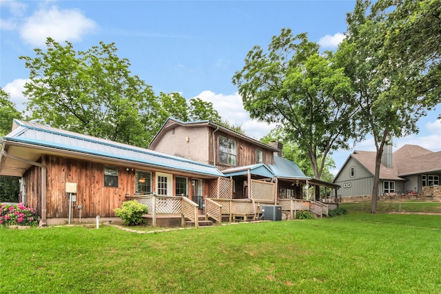 back of property featuring central air condition unit, a lawn, covered porch, and metal roof