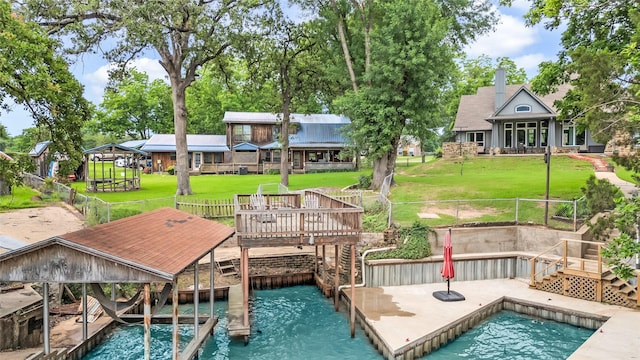 view of dock featuring stairway, a lawn, and fence