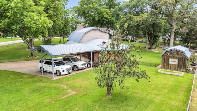 exterior space with a carport, a storage unit, an outdoor structure, and fence