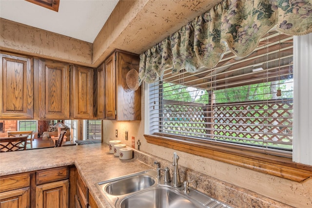 kitchen with brown cabinets, light countertops, and a sink