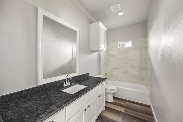 full bathroom with visible vents, toilet, wood finished floors, bathtub / shower combination, and vanity