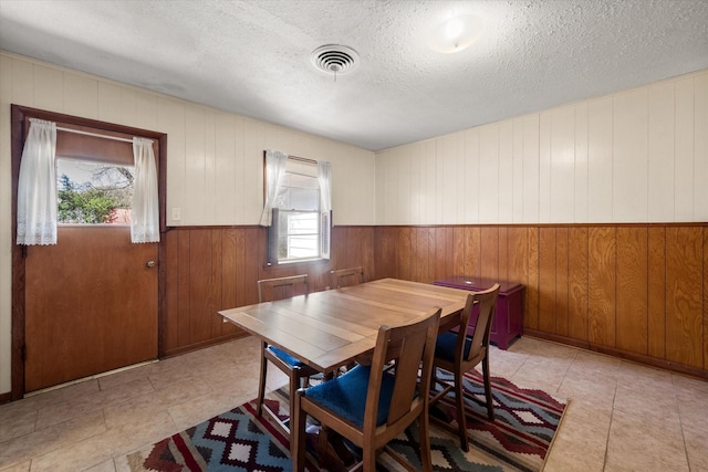 dining space featuring visible vents and a textured ceiling