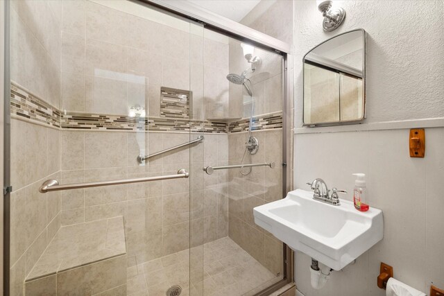 bathroom featuring a stall shower and a sink