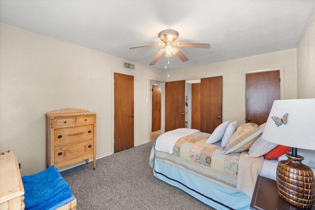 carpeted bedroom with visible vents and a ceiling fan