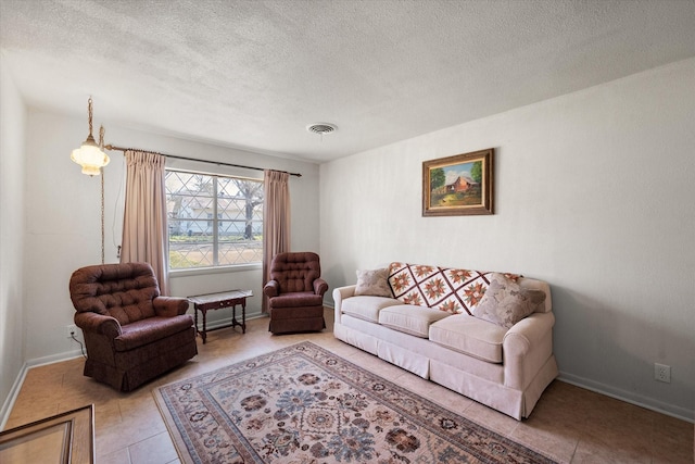 living area with light tile patterned floors, visible vents, a textured ceiling, and baseboards