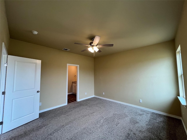 unfurnished bedroom with visible vents, a ceiling fan, ensuite bath, carpet, and baseboards