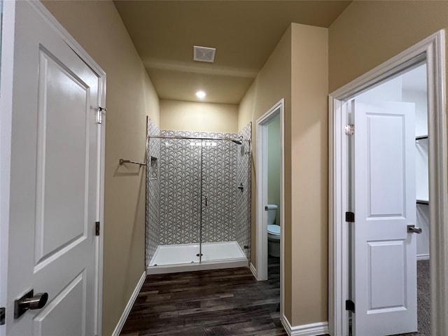 bathroom with visible vents, a shower stall, baseboards, toilet, and wood finished floors