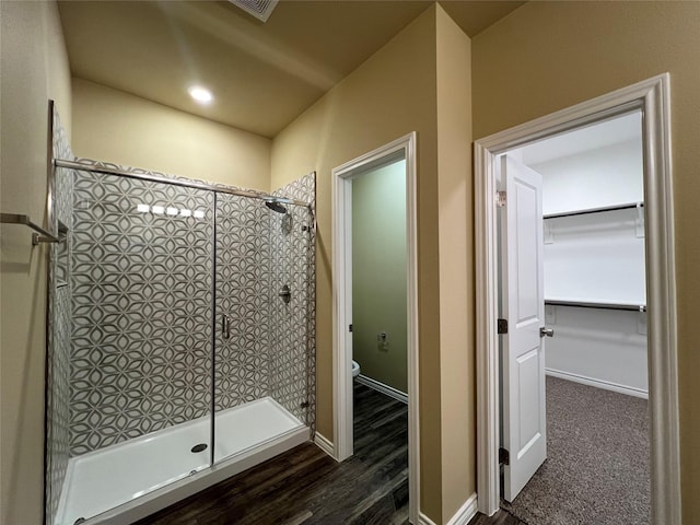 bathroom with a shower stall, toilet, and baseboards