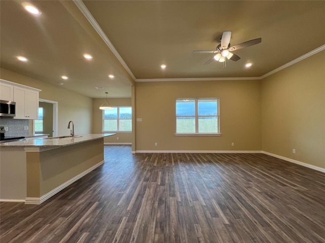 kitchen with stainless steel microwave, light stone countertops, dark wood finished floors, and white cabinets