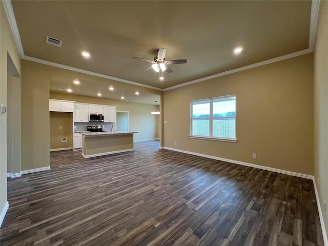 unfurnished living room with visible vents, ornamental molding, a ceiling fan, dark wood-style floors, and baseboards