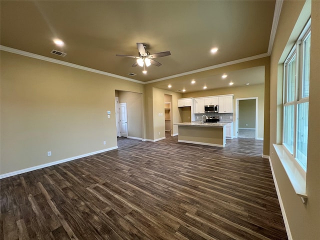 unfurnished living room with ceiling fan, crown molding, baseboards, and dark wood-style flooring