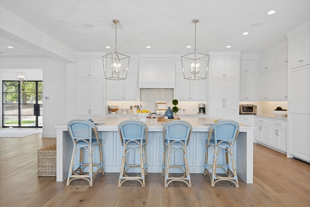 kitchen featuring an inviting chandelier, white cabinets, and light countertops