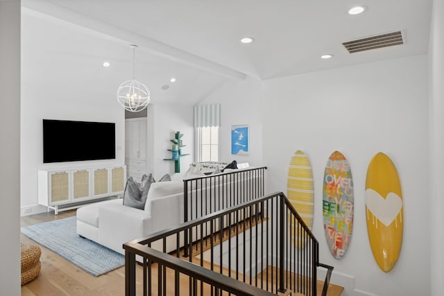 interior space with visible vents, vaulted ceiling with beams, recessed lighting, an inviting chandelier, and wood finished floors