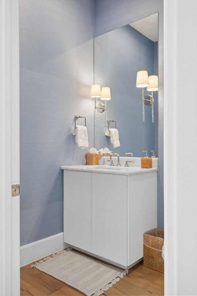 bathroom with vanity, wood finished floors, and baseboards