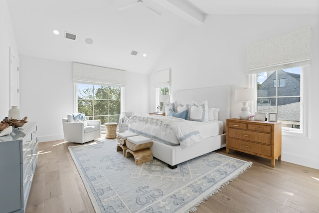 bedroom featuring visible vents, baseboards, beam ceiling, light wood-style flooring, and high vaulted ceiling