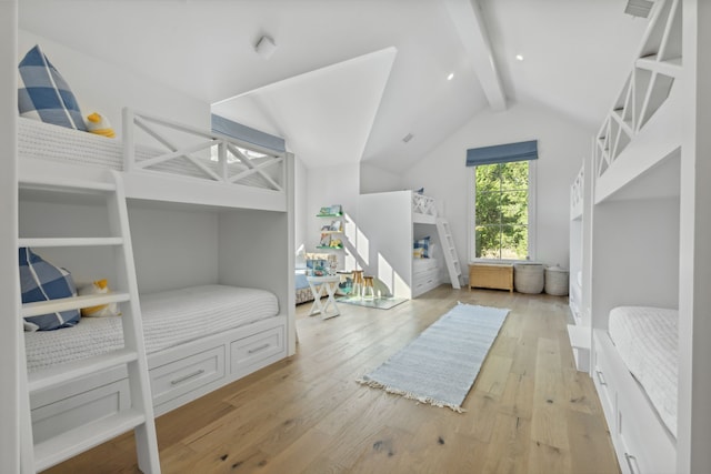 bedroom with light wood-style flooring and vaulted ceiling with beams