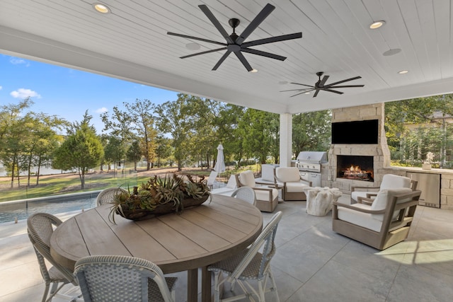 view of patio with a grill, ceiling fan, and an outdoor living space with a fireplace