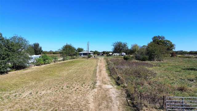 view of road featuring a rural view and dirt driveway