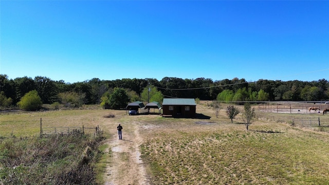 view of yard with a rural view, an outdoor structure, and fence