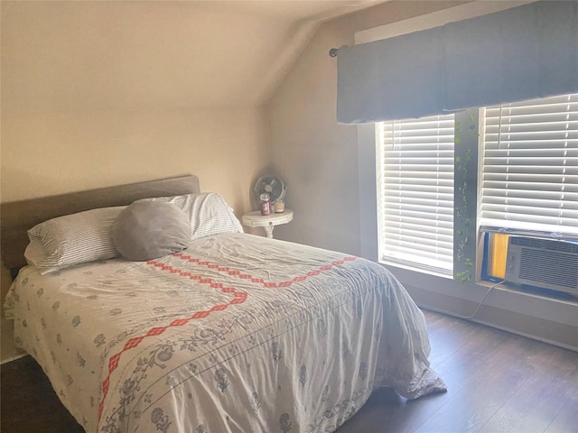 bedroom with vaulted ceiling, cooling unit, and wood finished floors