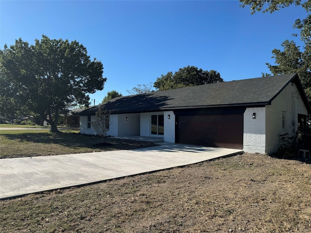 view of front of home featuring a garage, brick siding, and driveway