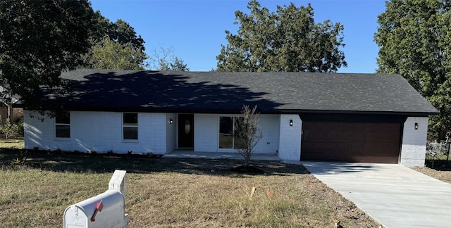 ranch-style home featuring a garage, brick siding, roof with shingles, and concrete driveway